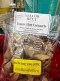 A clear plastic bag of Yellow Belt Candy Co. Tongue Hug Caramels filled with brown paper-wrapped candies, with a white product label on top and a yellow sticker reading 'to bring you JOY.